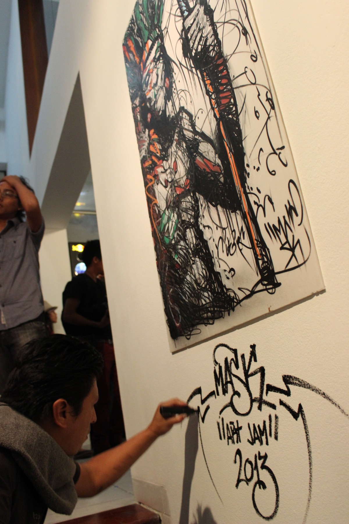 An artist from a previous year signs his work